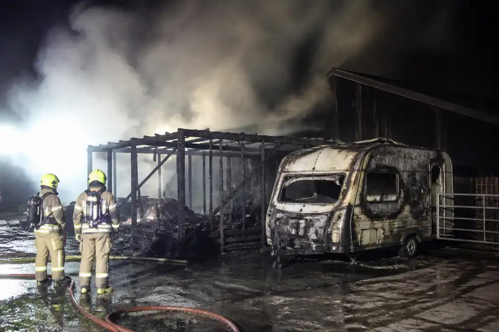 Brand verwoest chalet en caravan op landbouwbedrijf in Tremelo; bewoner naar ziekenhuis