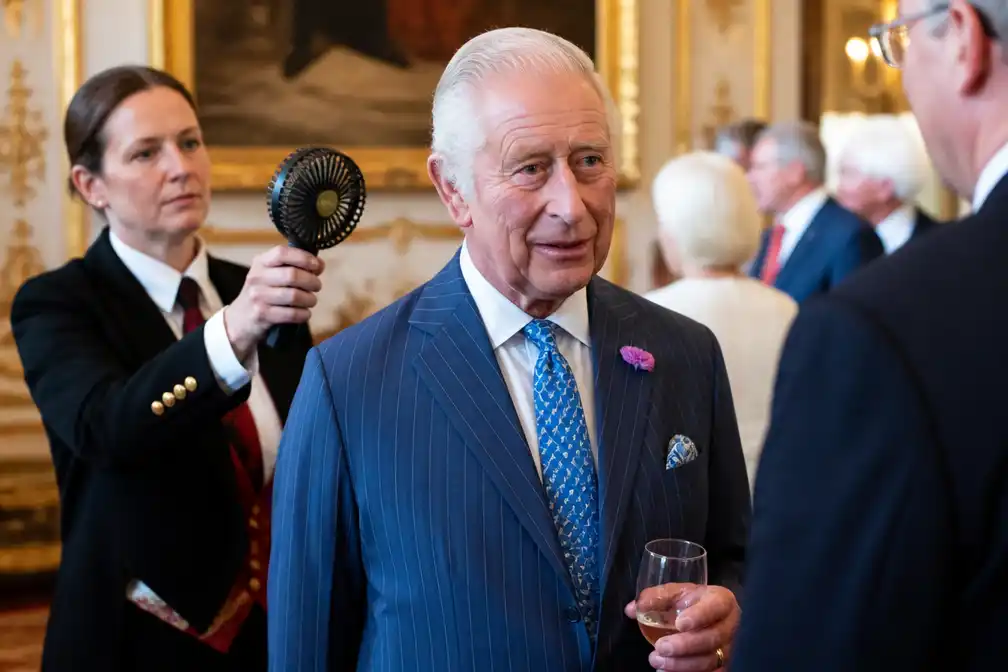 Assistent koelt koning Charles tijdens receptie in hittegolf Londen