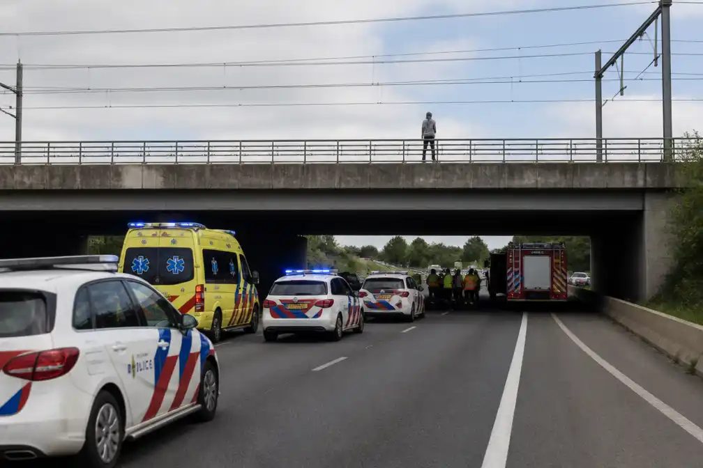 Man klimt op spoorbrug boven A4, snelweg dicht tussen Den Haag en Amsterdam